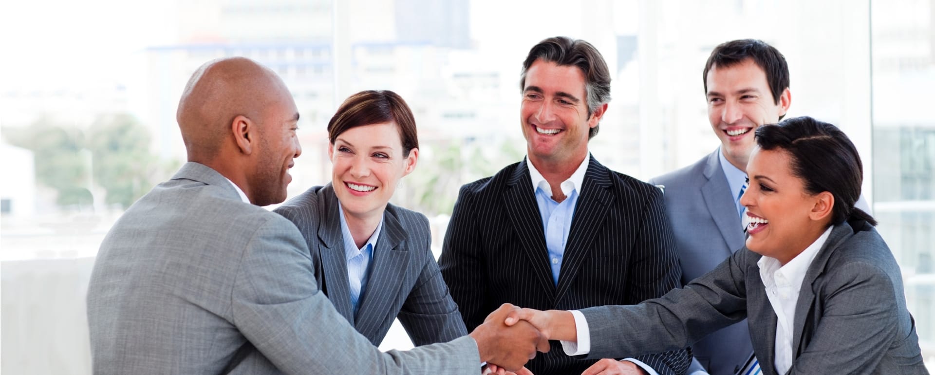 Business technology partners shaking hands during a successful IT consultation